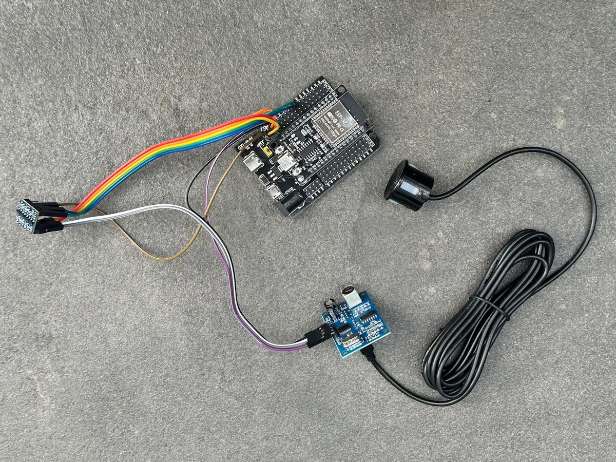 Vollständig verkabelter Aufbau aus ESP32 Expansion Board, MOSFET-Pegelwandler und JSN-SR04T-Ultraschallsensor mit farbcodierten Jumperkabeln